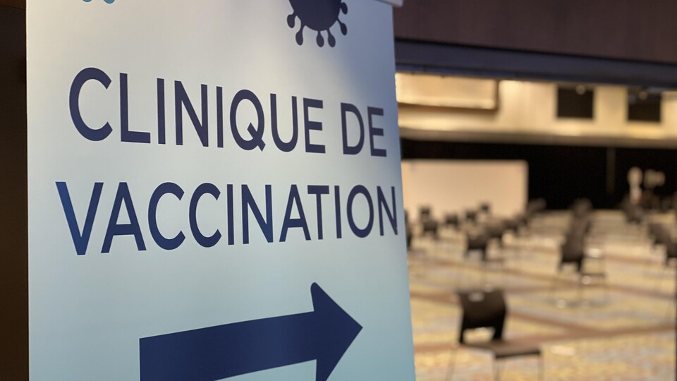 Un panneau indiquant la direction d'une clinique de vaccination.