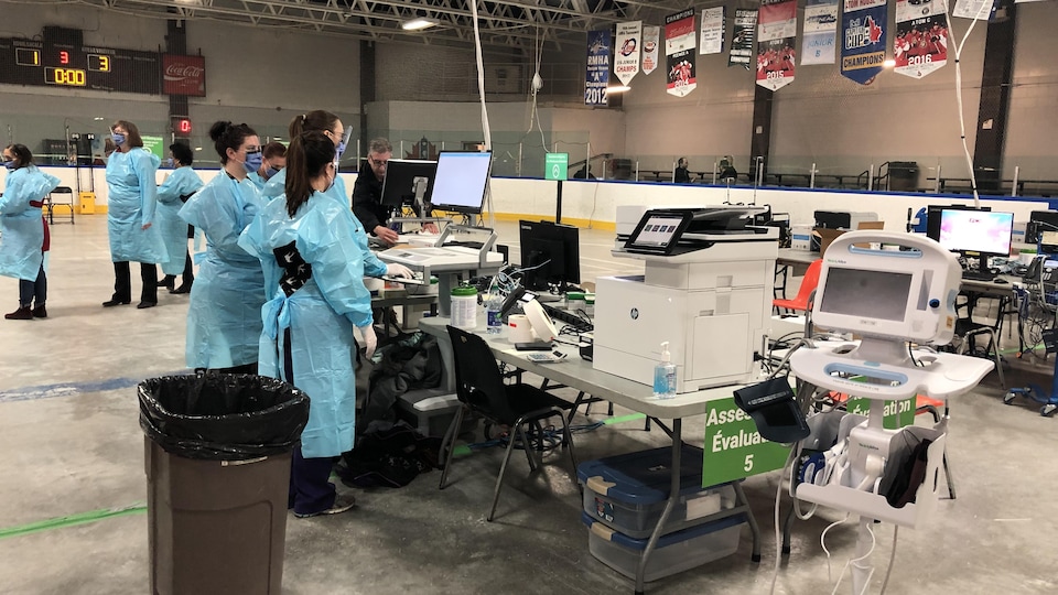 Un groupe d'infirmières devant des ordinateurs au centre de dépistage de la COVID-19 à l'aréna Brewer d'Ottawa