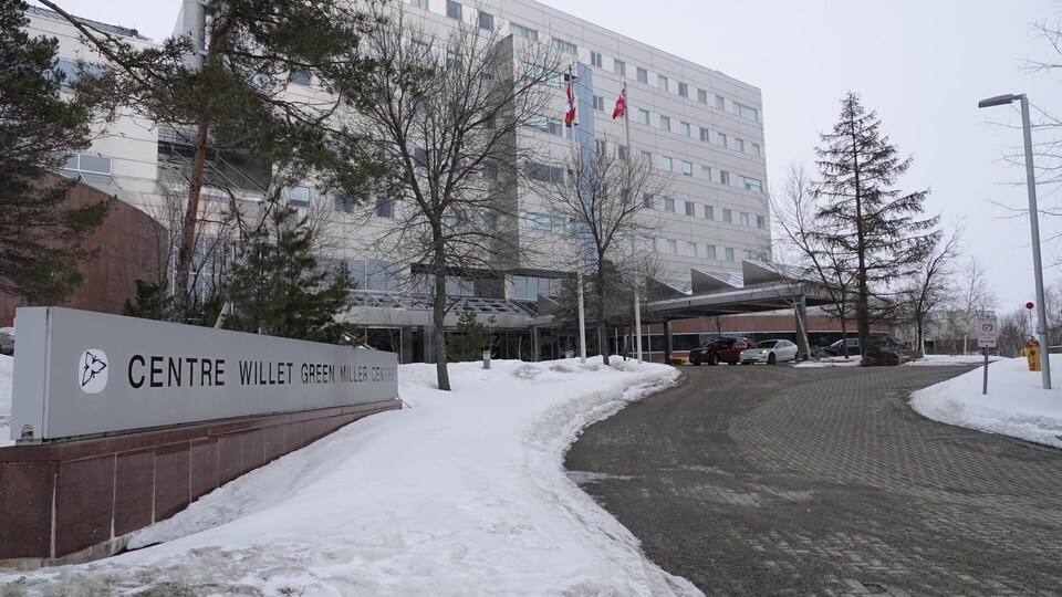 Un immeuble gris métallique avec des bancs de neige