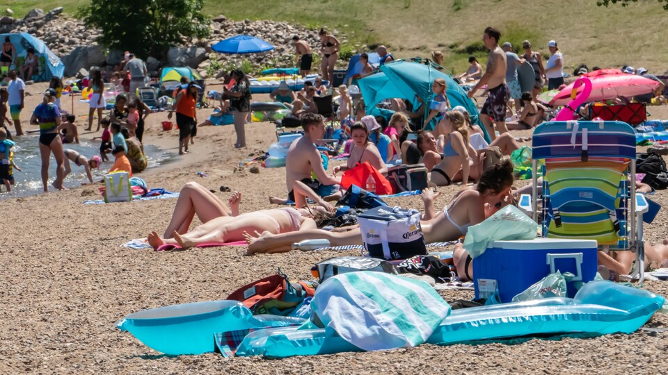 Des touristes profitent de la plage de Regina Beach, en Saskatchewan, lors d'une canicule.