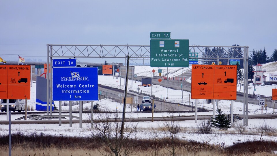 Des affiches le long de la route indiquent aux automobilistes de s'arrêter au point de contrôle.