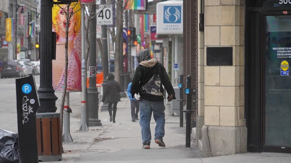 Un homme seul marche dans une rue de Montréal.