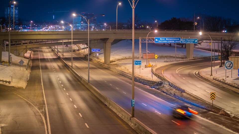Une seule voiture sur l'autoroute la nuit.