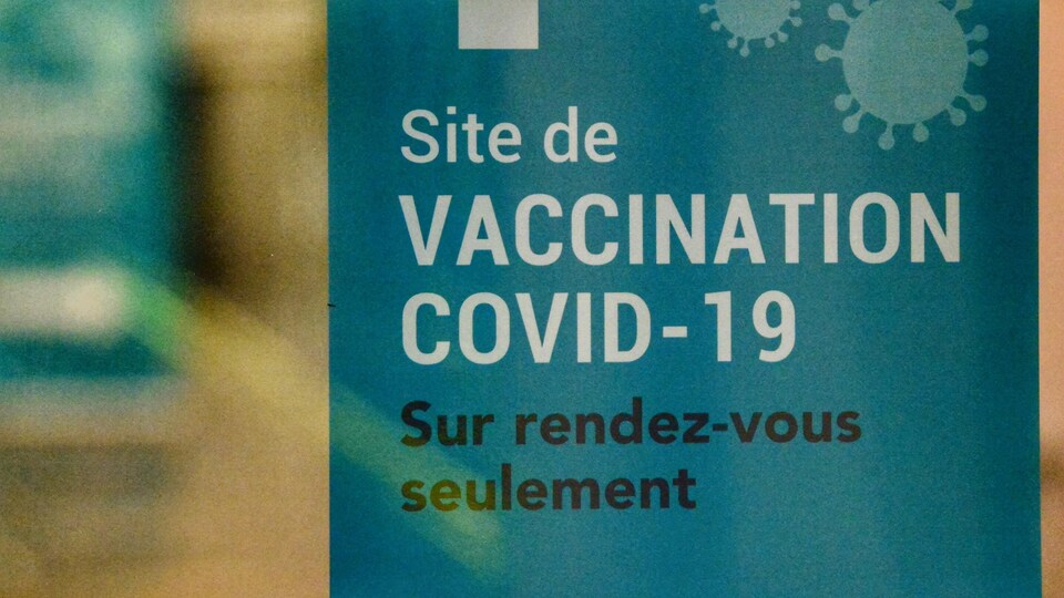 Gros plan sur une affiche qui indique l'entrée d'un site de vaccination sur rendez-vous.
