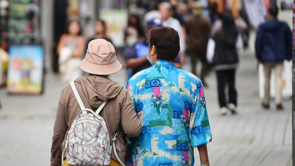 Deux personnes marchent dans la rue.