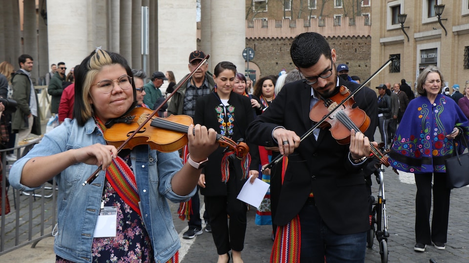 Des Métis du Canada, certains vêtus de vêtements traditionnels ou jouant du violon, sur la place Saint-Pierre au Vatican.