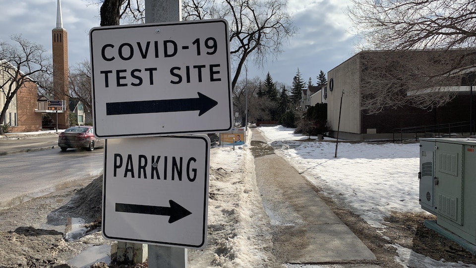 Une pancarte près du trottoir avec des informations qui indiquent que c'est un centre de dépistage de la COVID-19.