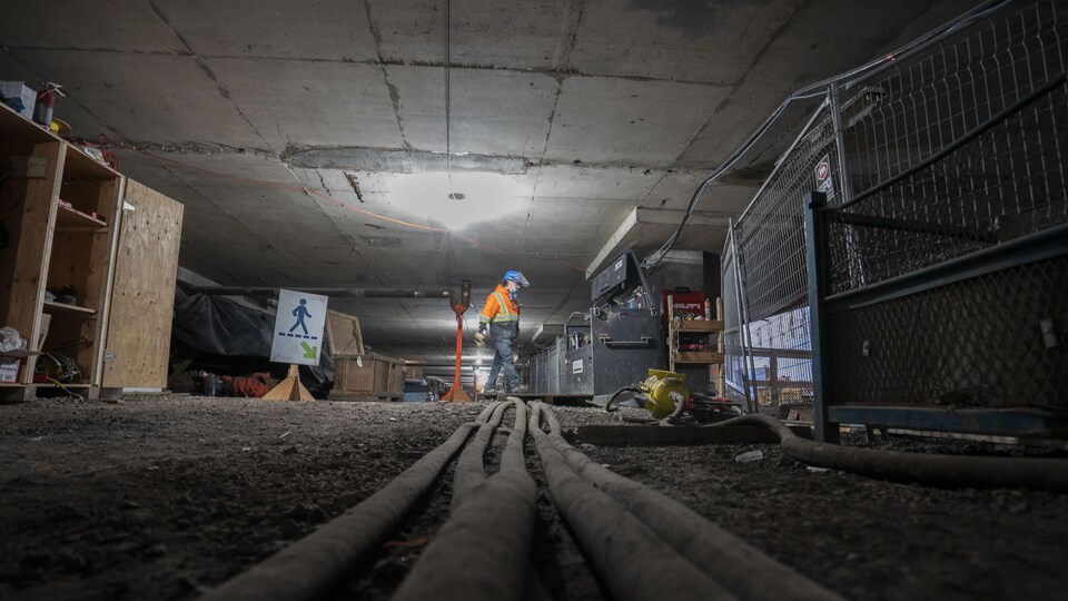Un ouvrier marche dans le chantier de construction d'un tunnel.
