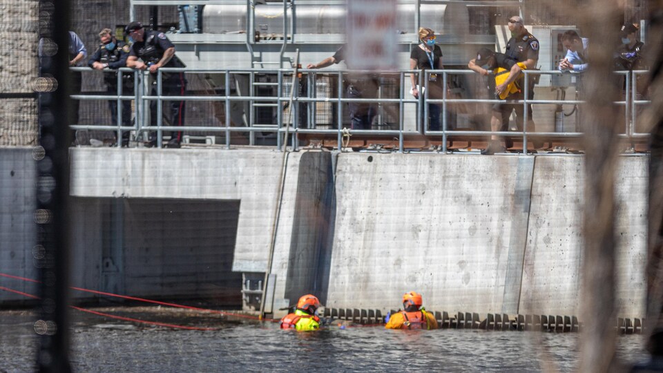 Deux personnes avec de l'équipement sont dans l'eau.