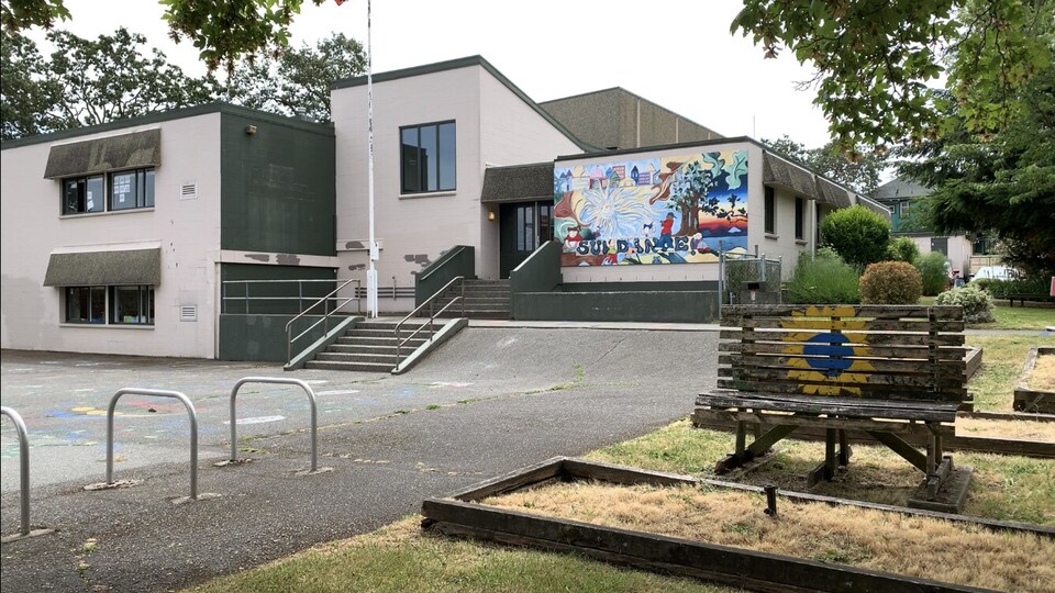 Le bâtiment scolaire est décoré d'une fresque et de tournesols.