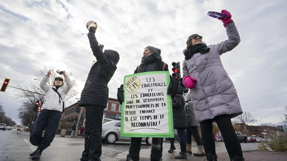 Des femmes manifestent sur un coin de rue, à Montréal.