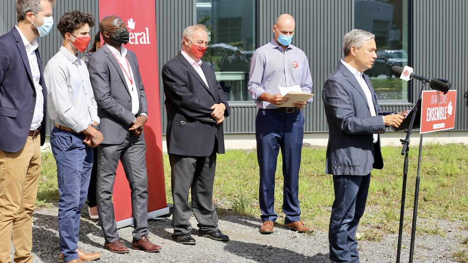 El secretario Champagne y otros parlamentarios liberales hacen un anuncio fuera de las instalaciones de Medicago.