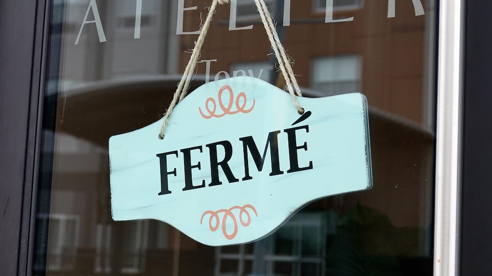 Un écriteau « fermé » suspendu à la porte vitrée d'un commerce le 4 février 2021 à Dieppe au Nouveau-Brunswick.