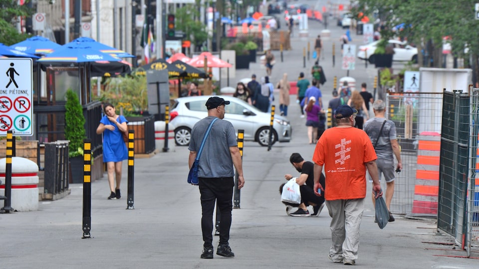 Des passants déambulent dans une rue piétonnière de Montréal.