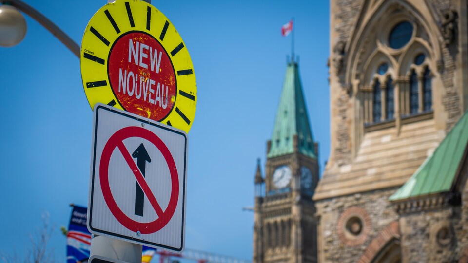 Un panneau indique la nouvelle signalisation sur la rue Wellington à Ottawa, qui est fermée à la circulation.