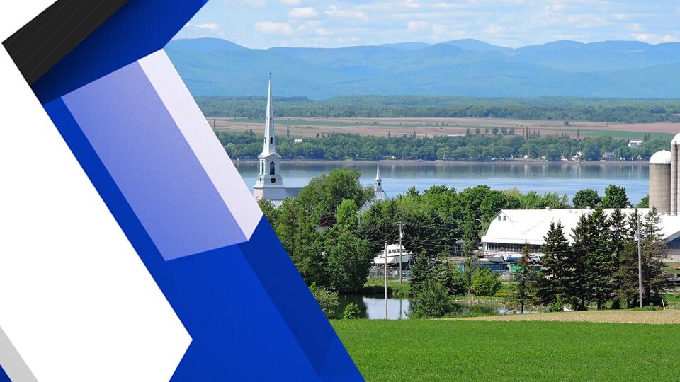 Des bâtiments agricoles et l'église du village de Saint-Michel-de-Bellechasse en été. En arrière-plan apparaissent le fleuve Saint-Laurent, l'île d'Orléans et les contreforts des montagnes du parc des Laurentides.