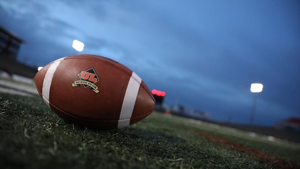 Un ballon de football aux couleurs du Rouge et Or de l'Université Laval.