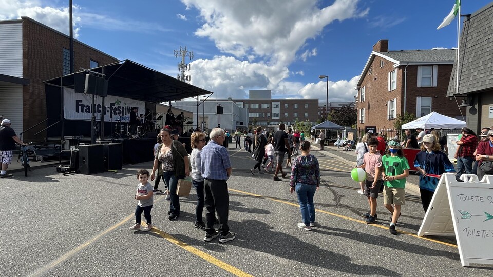 Une foule devant une scène installée dans la rue.