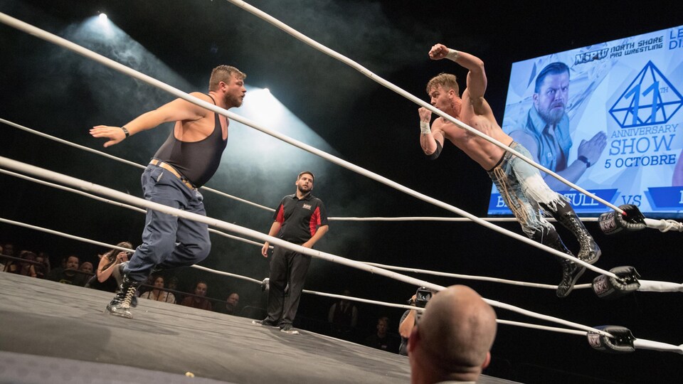 Un lutteur se lance sur un autre dans le ring.
