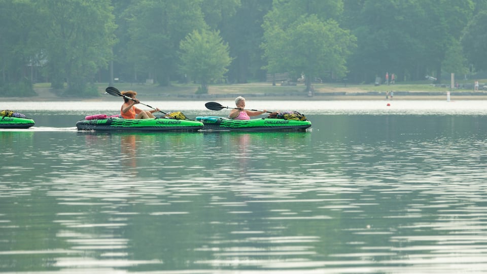 Deux femmes dans deux kayaks sur un lac paisible.