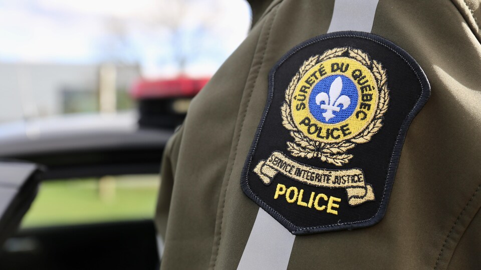 Le blason de la SQ cousu sur la veste d'un policier.