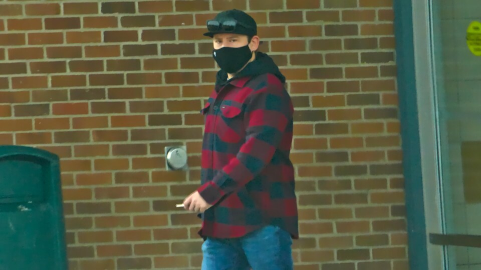 Un homme porte un masque à l'extérieur pendant la pandémie de la COVID-19 à Regina en hiver.