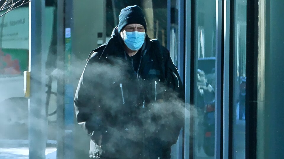 Un homme porte un couvre-visage à l'extérieur. 