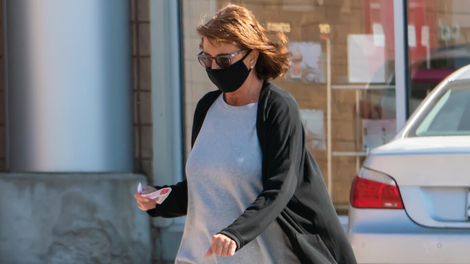 Une femme porte un masque.