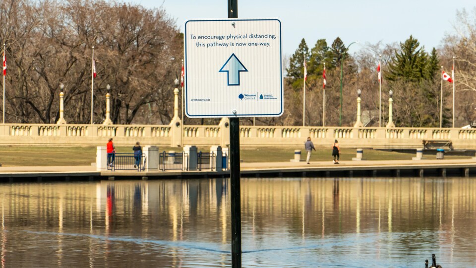 Une affiche indiquant la direction dans laquelle les passants doivent marcher autour du lac Wascana.