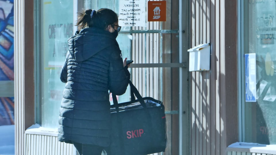 Une personne porte un sac de livraison d'un restaurant.