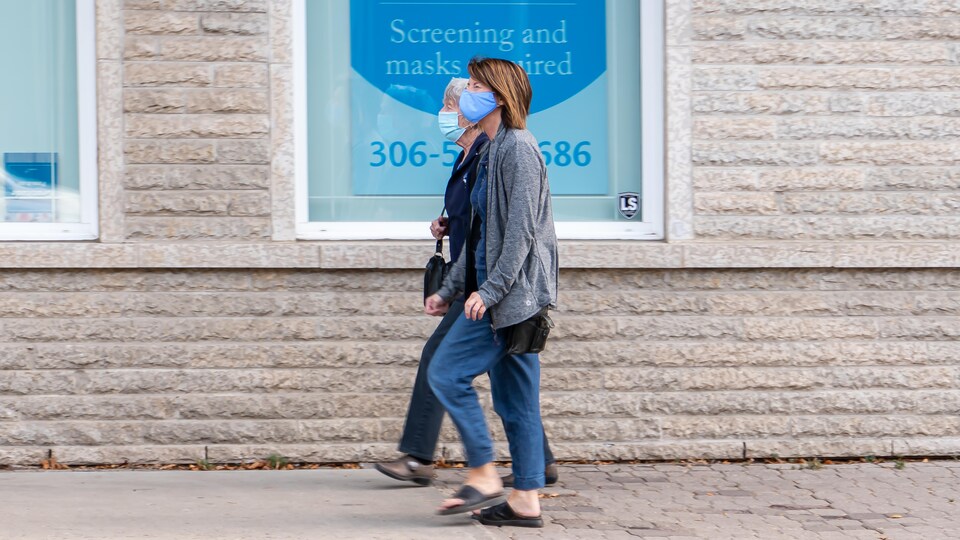 Des femmes portent des masques à l'extérieur pendant la pandémie de la COVID-19 à Regina en automne.