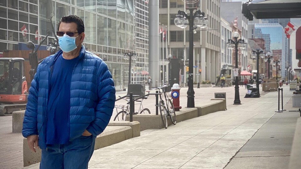 Un piéton portant le masque marche dans le centre-ville d'Ottawa.