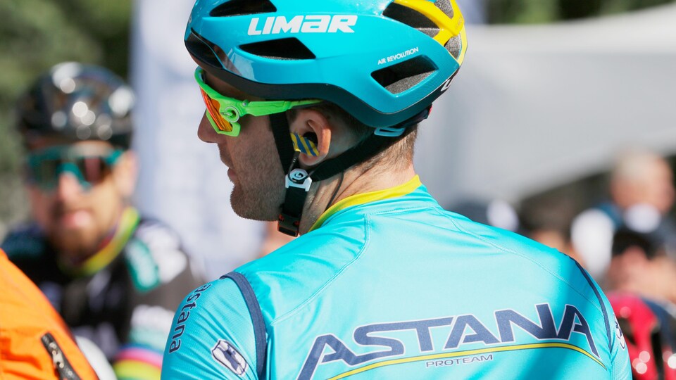Gros plan d'un coureur de dos, avec son maillot turquoise