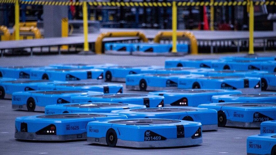 Une flotte de petits robots bleus de petite taille, semblables à de grosses boîtes de pizza.