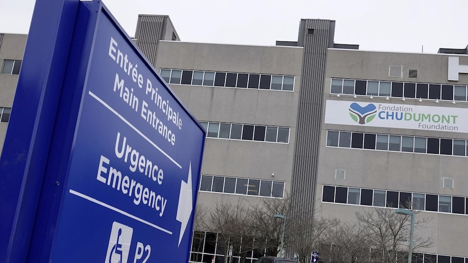 Une enseigne pointant l'entrée de l'urgence et le bâtiment de l'hôpital.