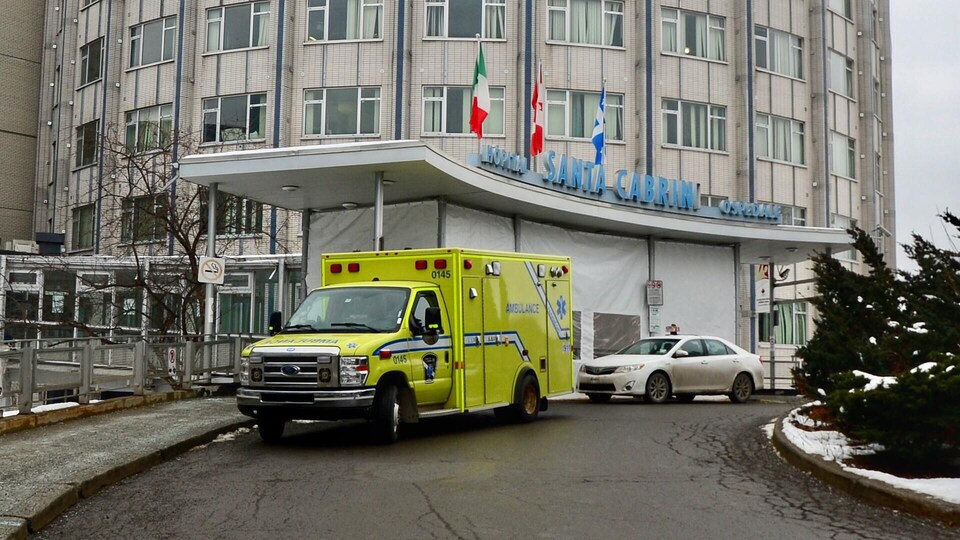 Entrée de l'Hôpital Santa Cabrini. Une ambulance est stationnée devant.