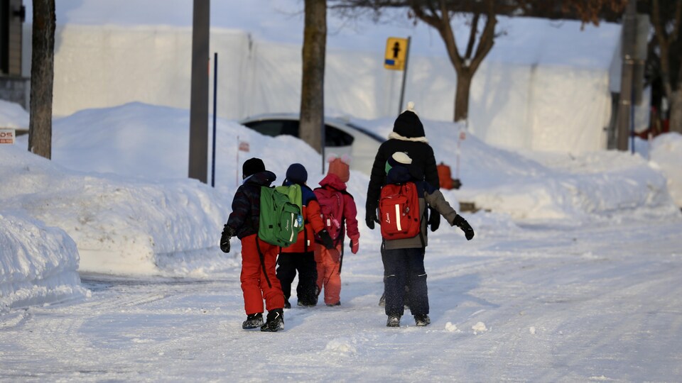 Des élèves sortent de l'école pour retourner chez eux.