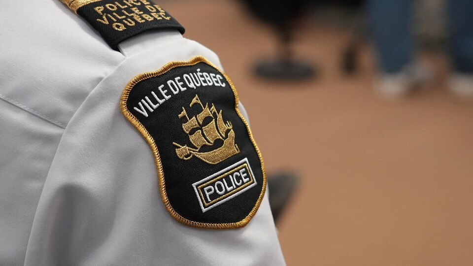 L'insigne de la police de Québec sur la manche d'une chemise.