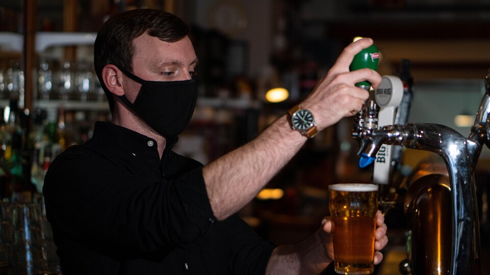 Un serveur sert une bière à la pression.