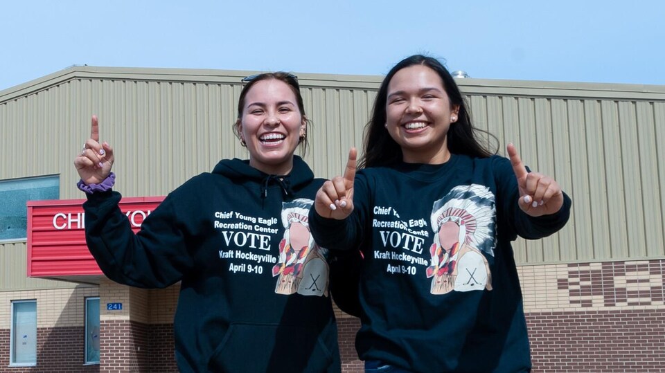 Deux jeunes Autochtones souriantes montrent le chiffre un avec leurs mains.