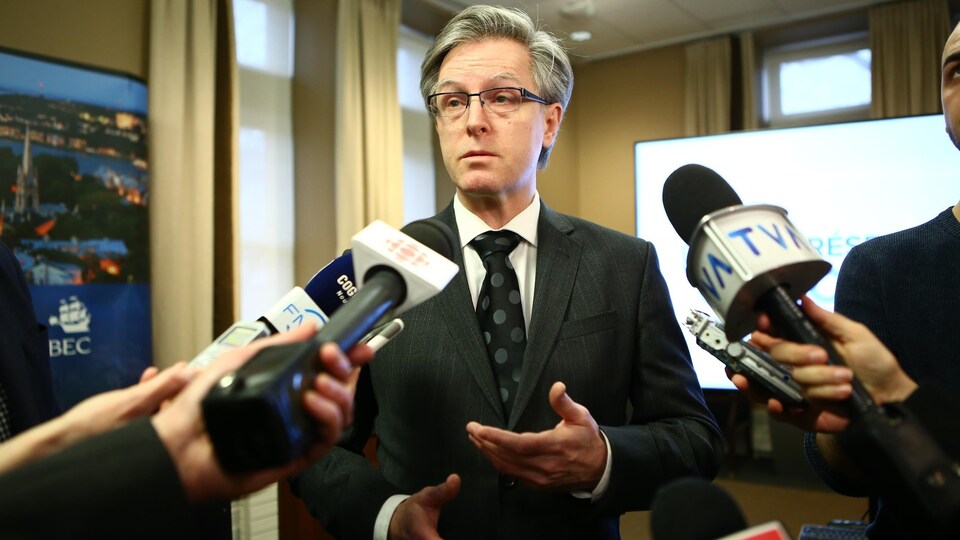 Jean Rousseau répond aux journalistes dans une salle de l'hôtel de ville