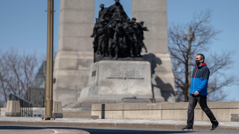 Une homme portant le masque marche à Ottawa.