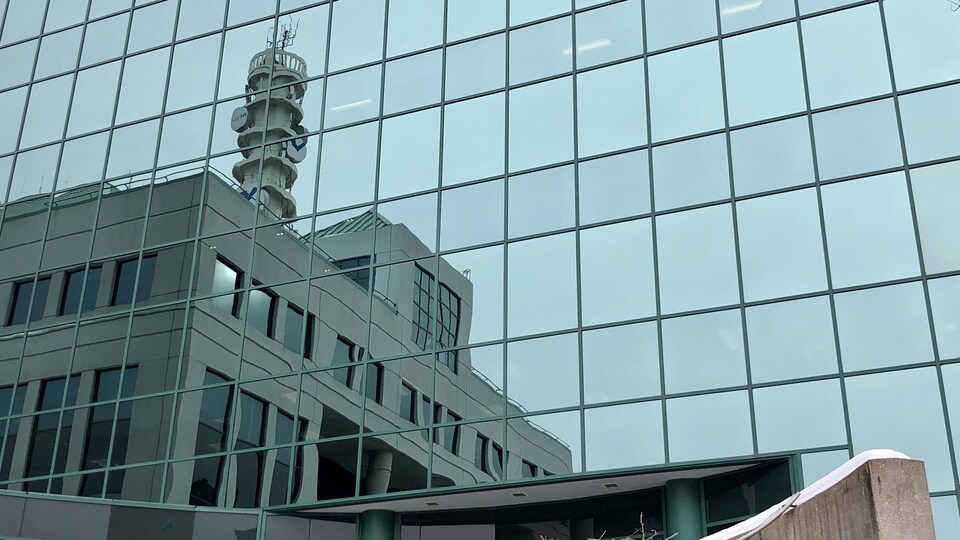 L'hôtel de ville se reflète sur la façade vitrée d'un bâtiment voisin.