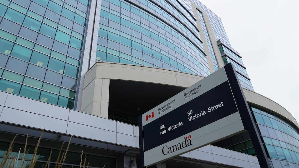 Un panneau devant un édifice du gouvernement du Canada.