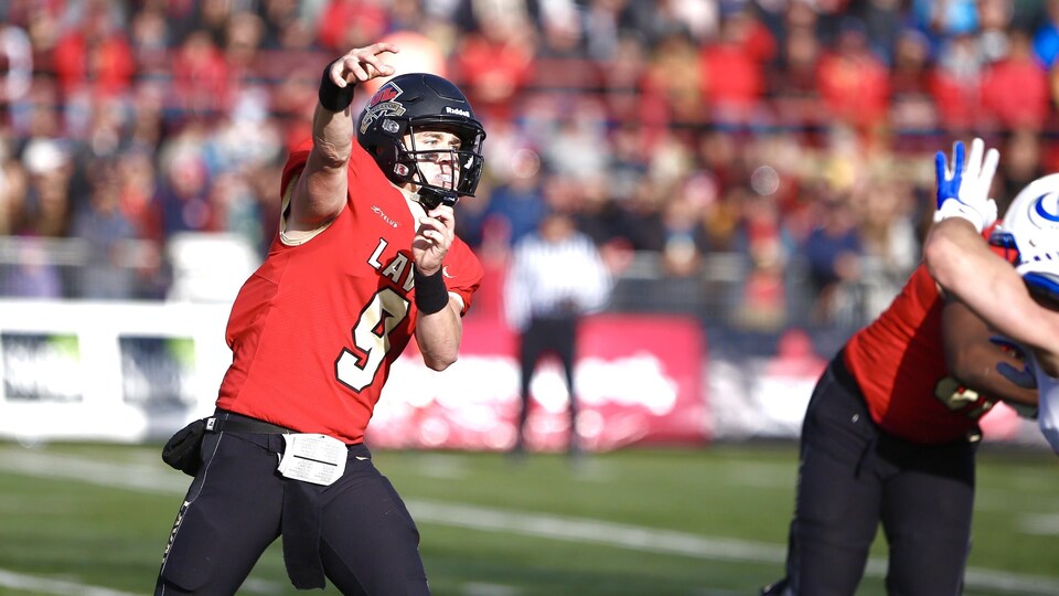 Le quart-arrière Thomas Bolduc décoche une passe durant un match.