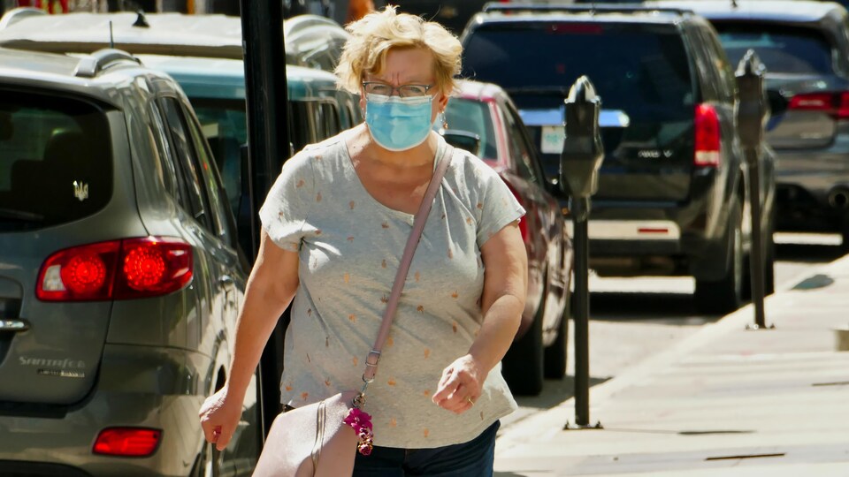 Une femme porte un masque.
