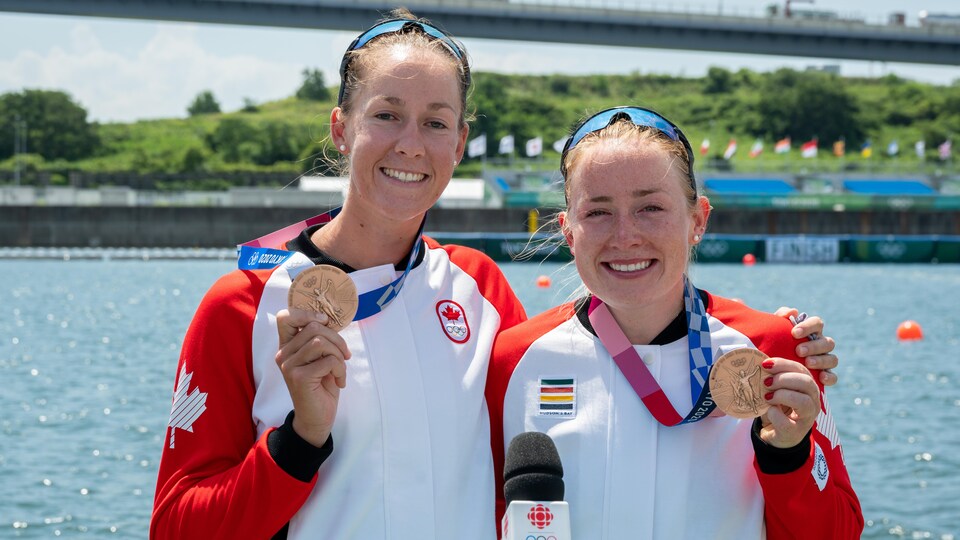 Les deux athlètes souriantes montrent leurs médailles.