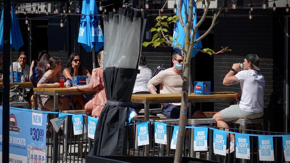Des gens boivent et mangent sur une terrasse.