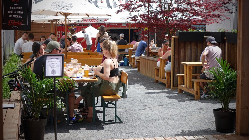 Une terrasse avec des personnes assises.