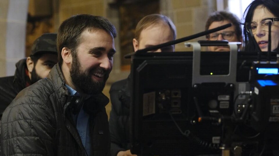 Le réalisateur Jonathan Keiser devant un écran de montage en compagnie d'une équipe de production.